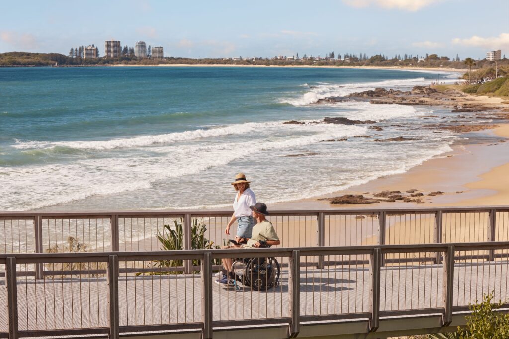Couple enjoying the pathway following the coastline of Mooloolaba Beach towards Alexandra Headland
