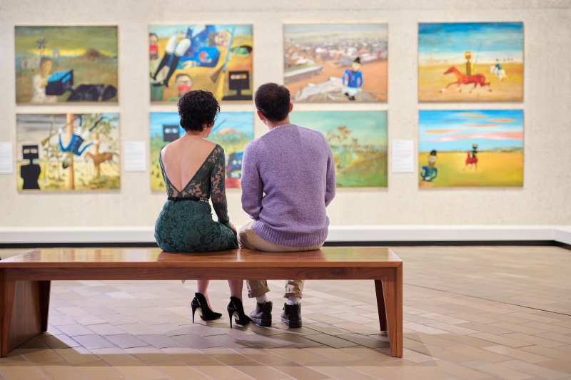 Inside the National Gallery of Australia, visitors move through a light-filled gallery space hung with works from the national collection.